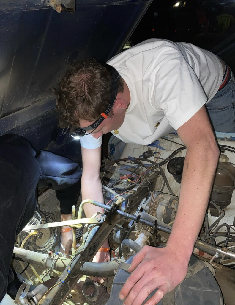 Charles repairs the car's engine